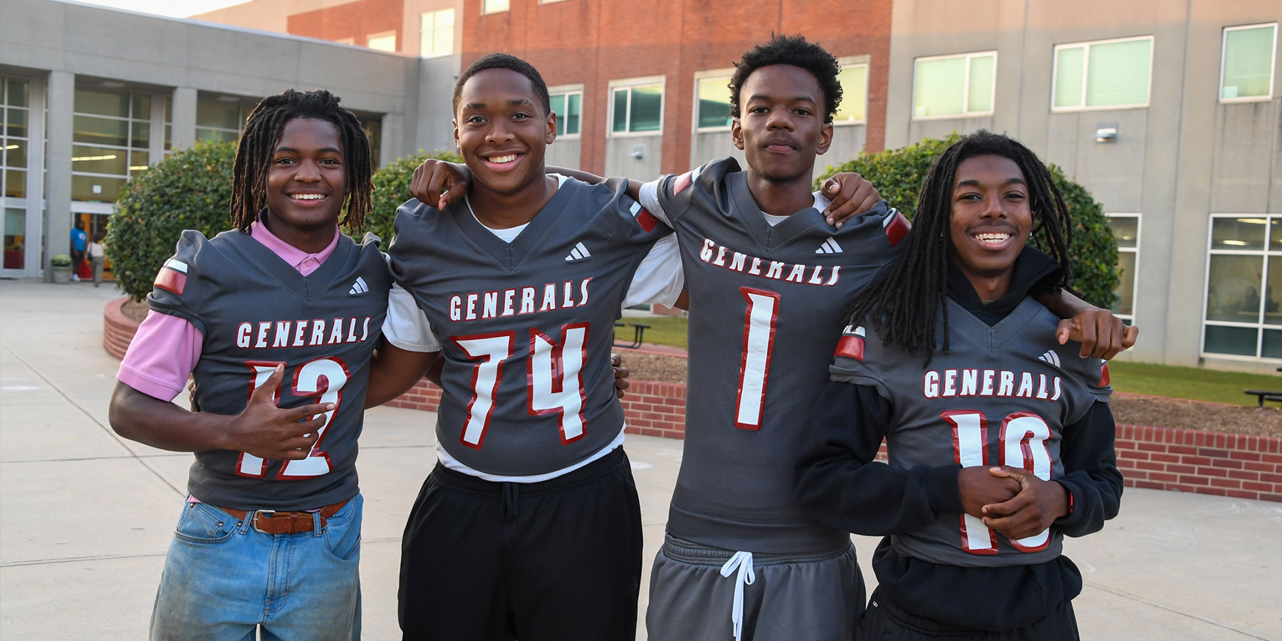 Four high school football players smiling