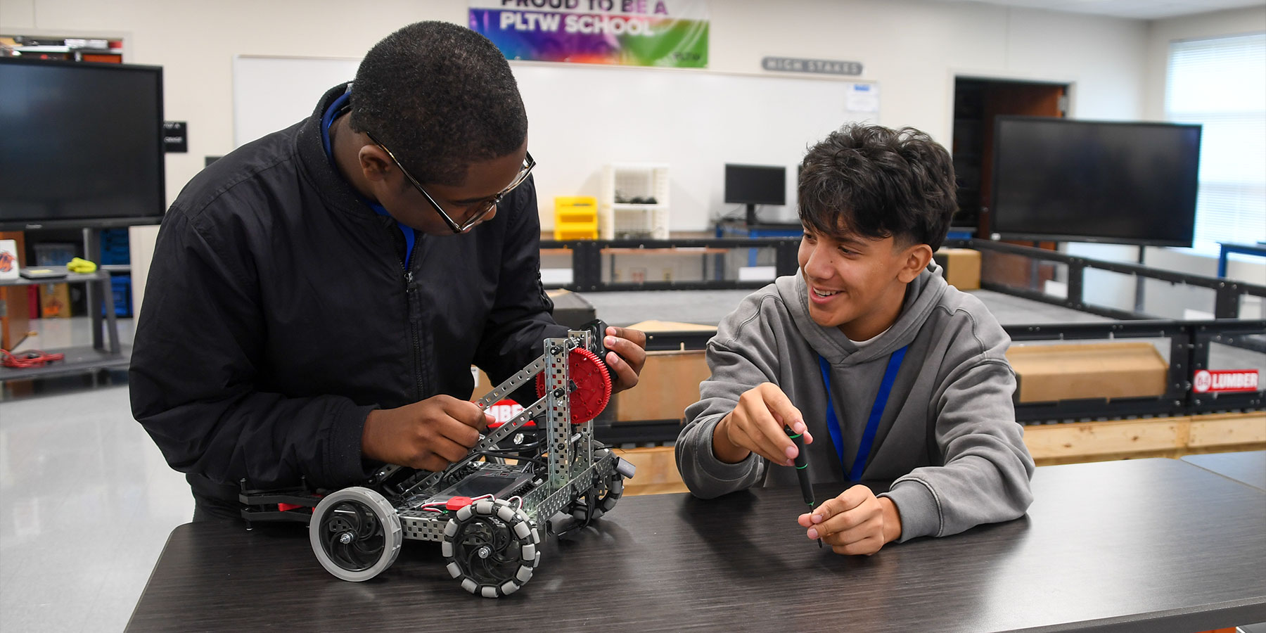 two middle school students working on a robot