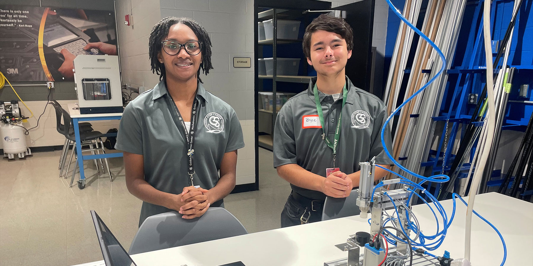 two career center students posing with a robot