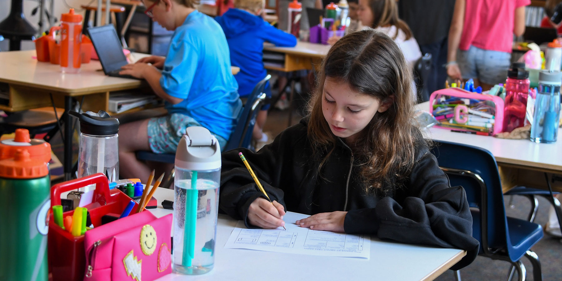 elementary girl sitting at desk doing work