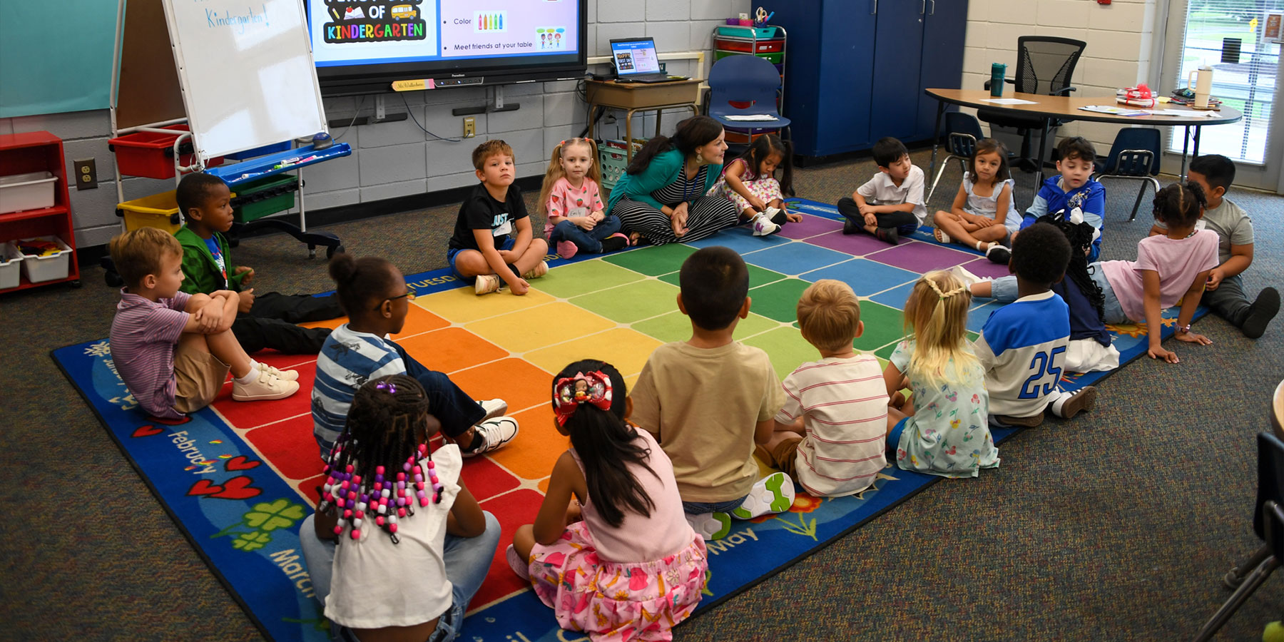 elementary students sitting in a circle on a rug