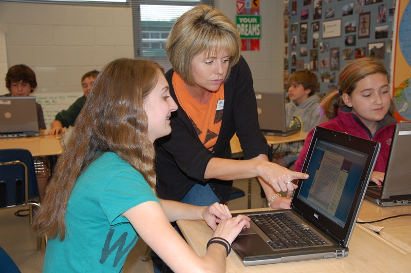 Seventh grade social studies teacher Michelle Satterfield assists a student with researching an American History topic.