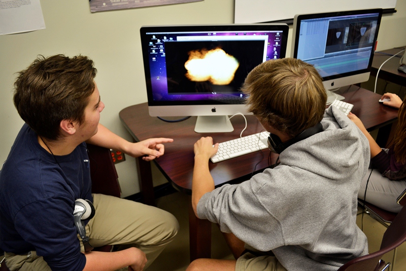 two students using a computer to design a graphic
