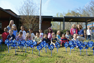 Four-year-olds at Northwest Crescent Child Development Center plant a pinwheel garden in front of the school in recognition of Child Abuse Prevention Month.