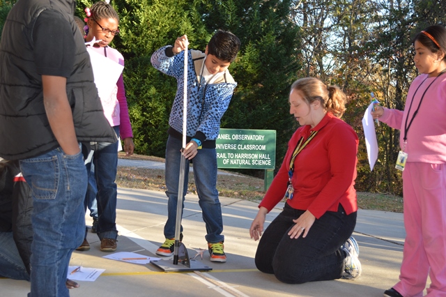 female teacher with a group of students doing an outside rocket launch activity