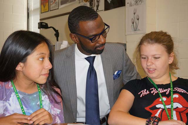 Damon Qualls with two female students
