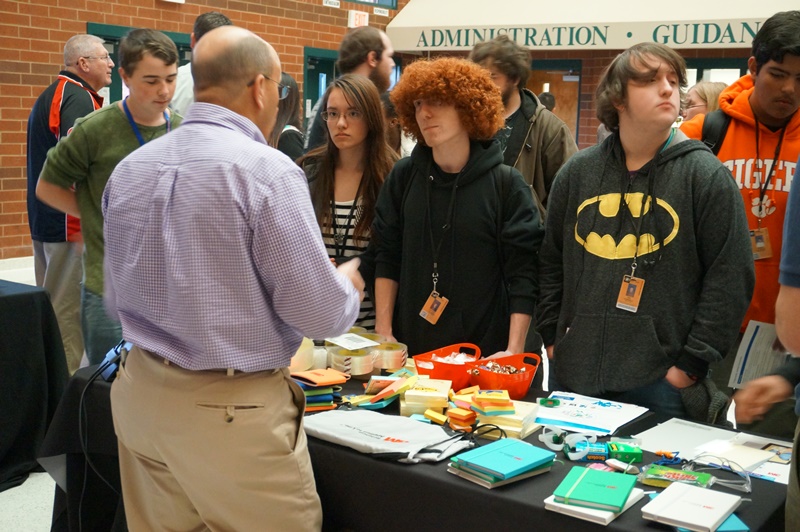 As they browse the display tables at Greer High School, students are finding out what kinds of careers they could have in Advanced Manufacturing. 