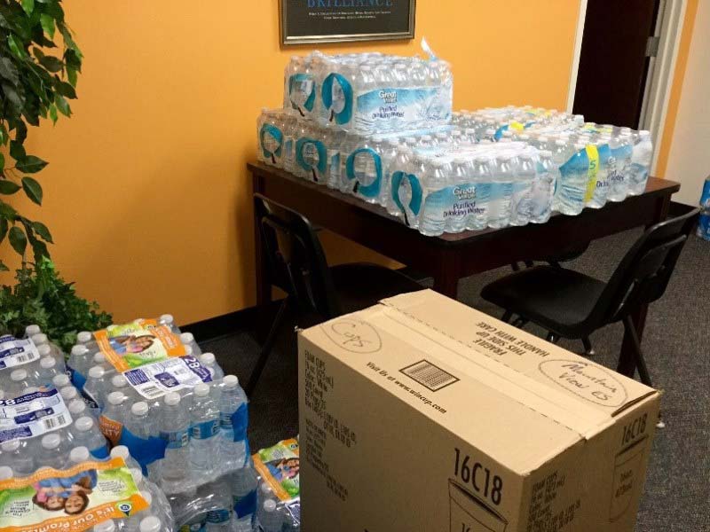 Cases of water stacked on a table in an office