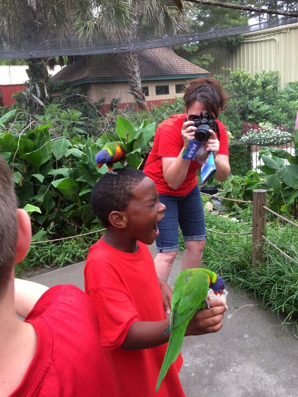 3rd grade student at AJW holding parrot