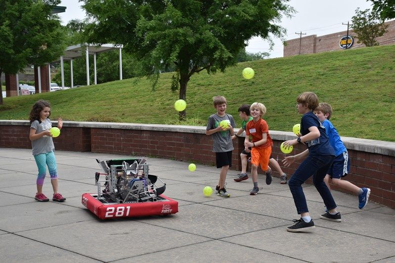 group of students outside with a robot
