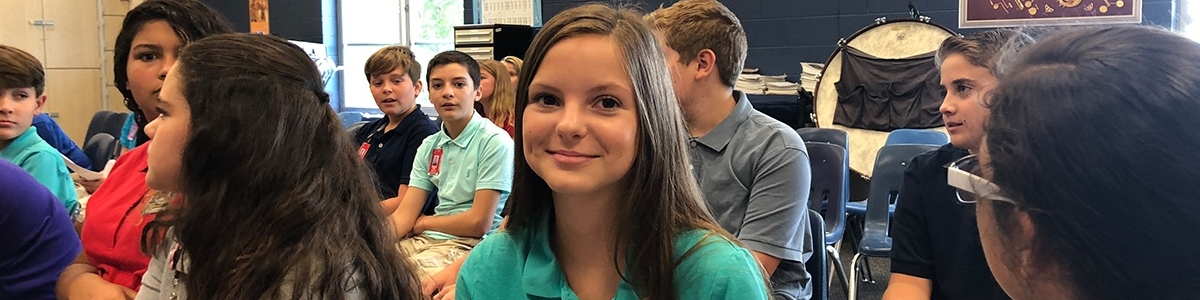 Smiling girl in a classroom of students