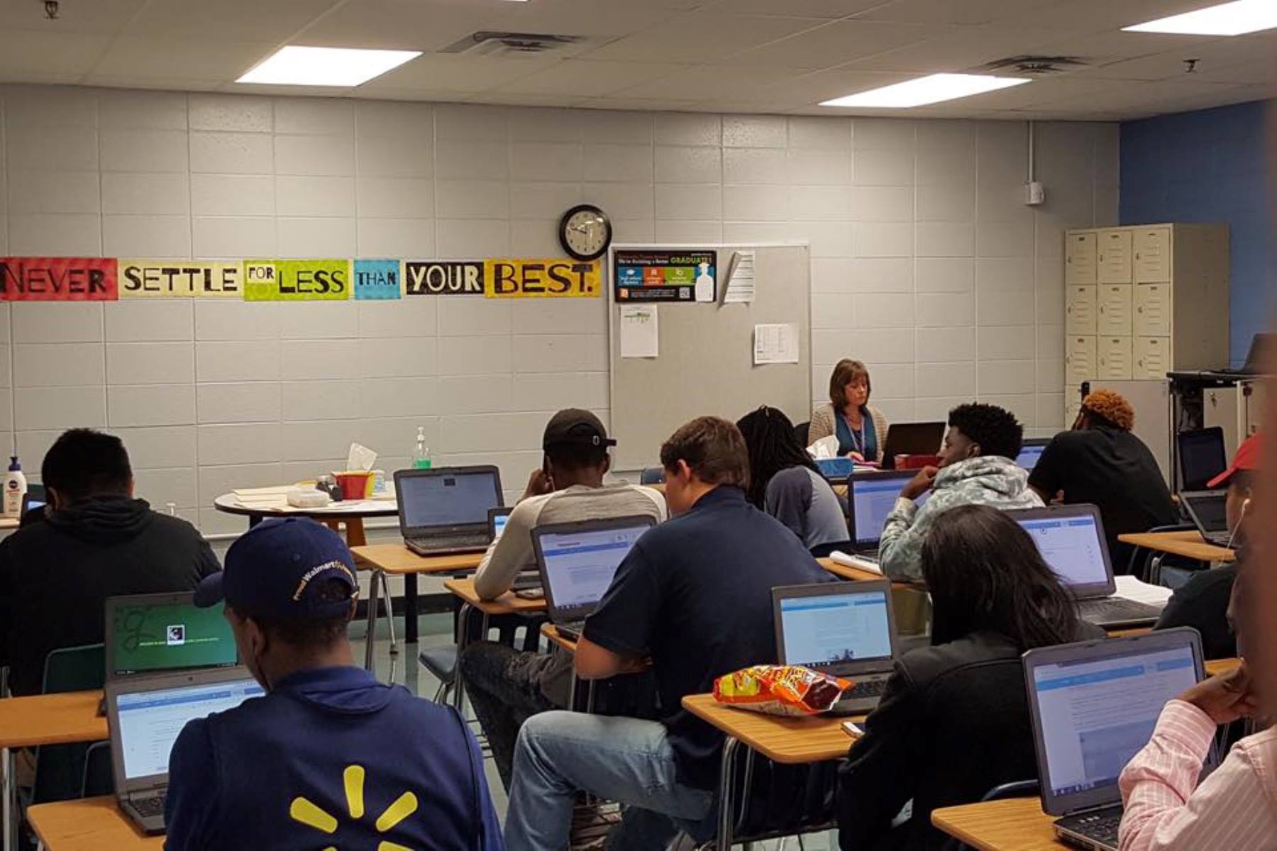 High School students in a classroom, each with a laptop computer on their desks