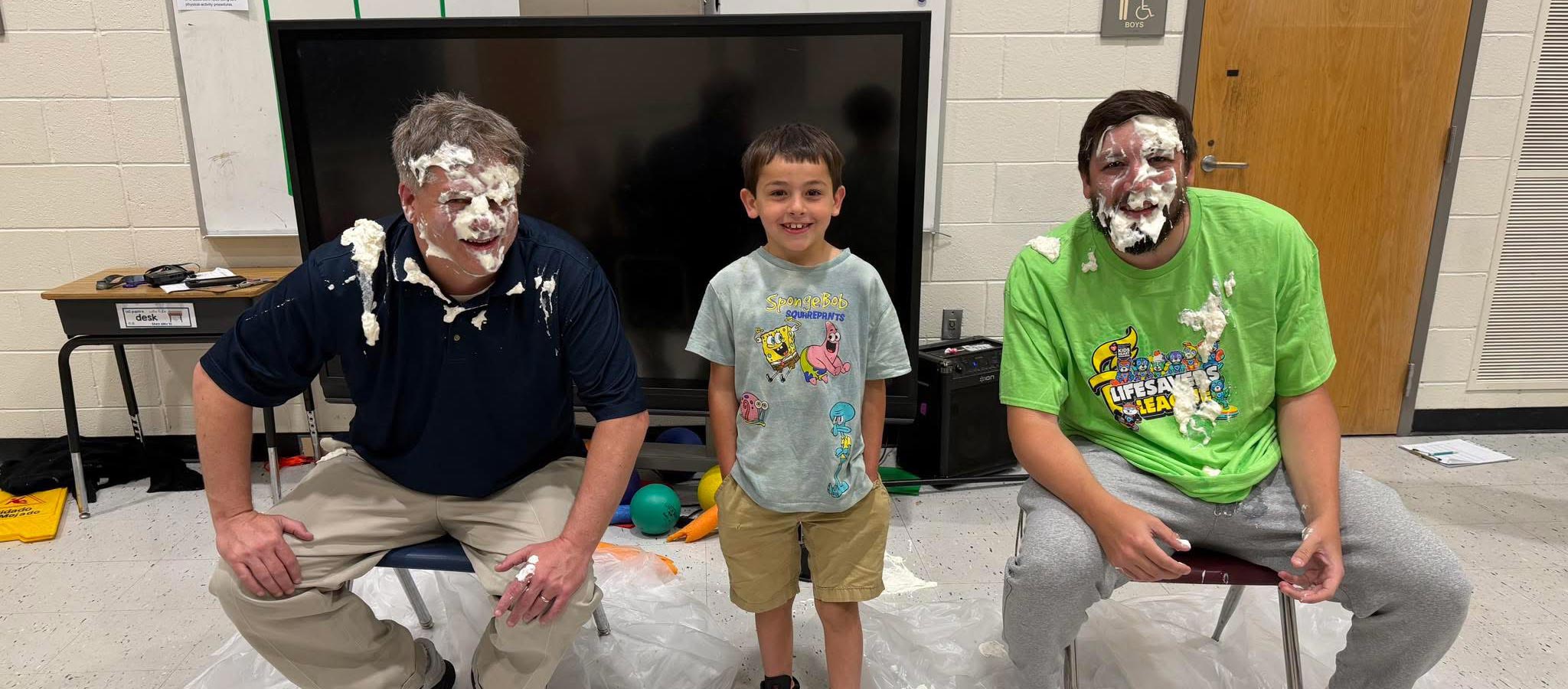teachers with pie on their faces with a student