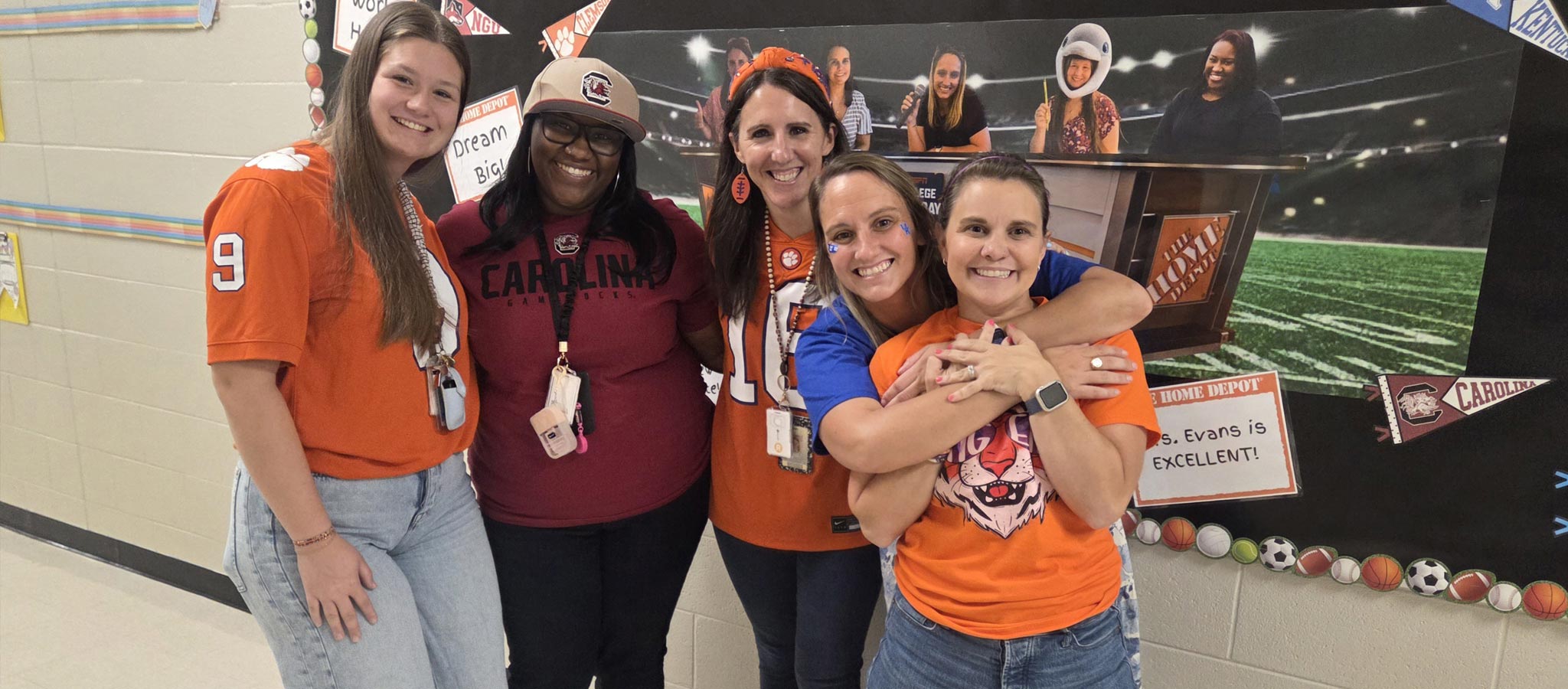 5 staff members wearing college spirit jerseys