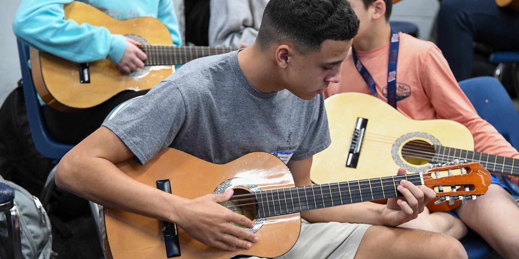 male high school students playing guitars