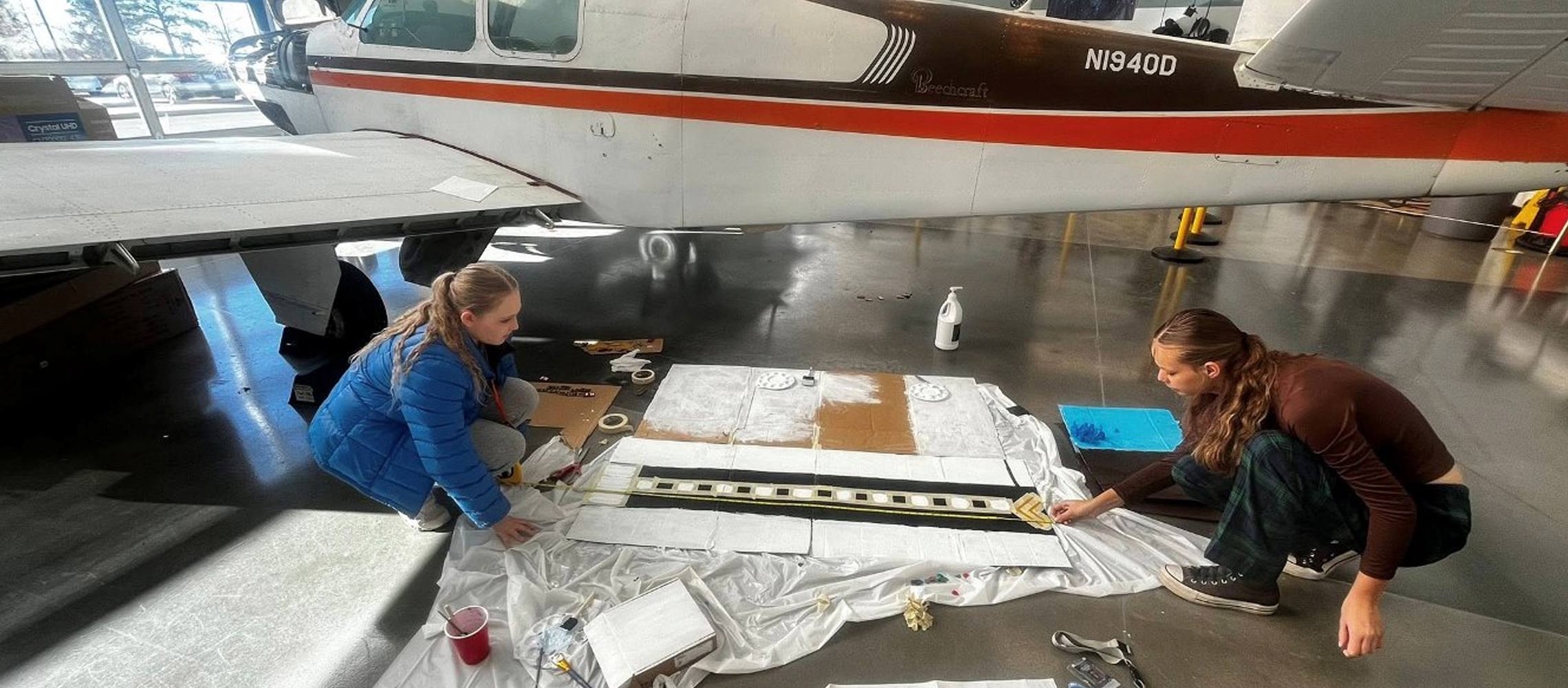 students designing a runway near an airplane