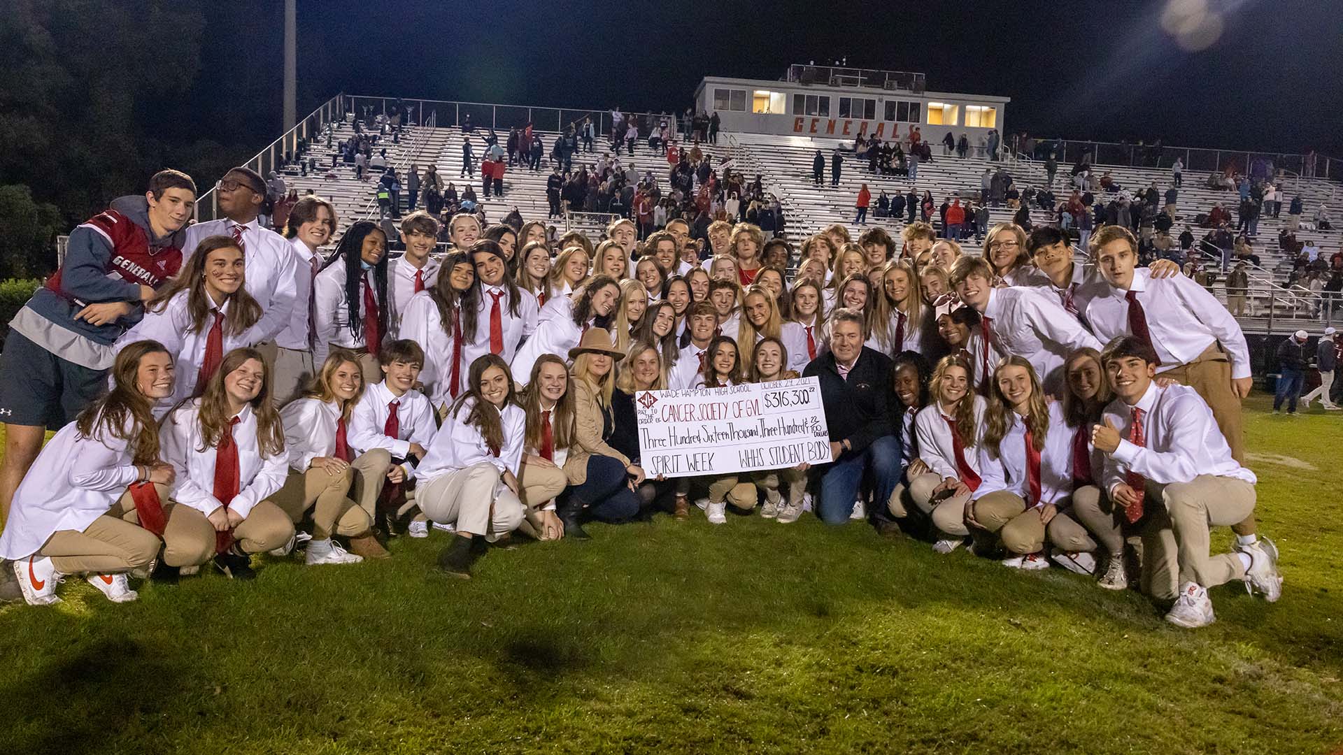 The check reveal from the 2021 Spirit Week benefiting Cancer Society of Greenville. Students surround a large check for $316,300.22